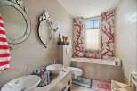 This stunning bathroom boasts a unique design with coral-inspired mosaic tiles and elegant decorative mirrors.