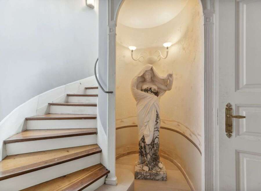 Step into luxury with this stunning property featuring a grand staircase and an elegant statue.