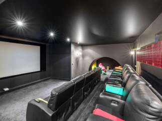 Step into luxury with this stunning home theater! Featuring plush black leather seating, a massive screen, and a sleek, modern design, it's the perfect space for movie nights.
