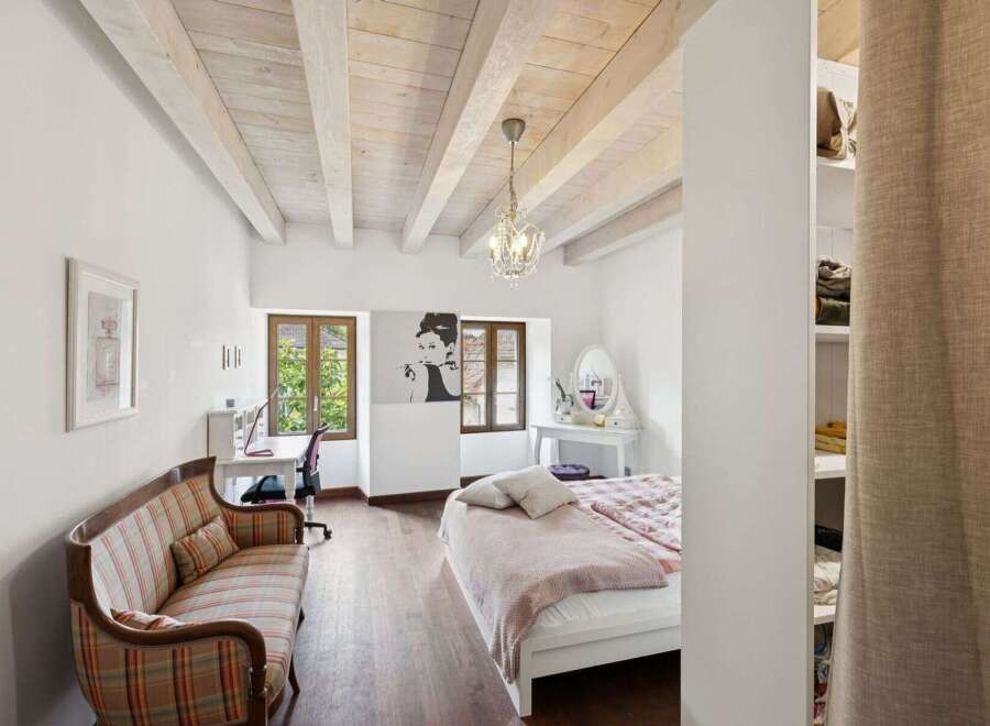 This charming bedroom boasts a unique blend of rustic and elegant design elements.