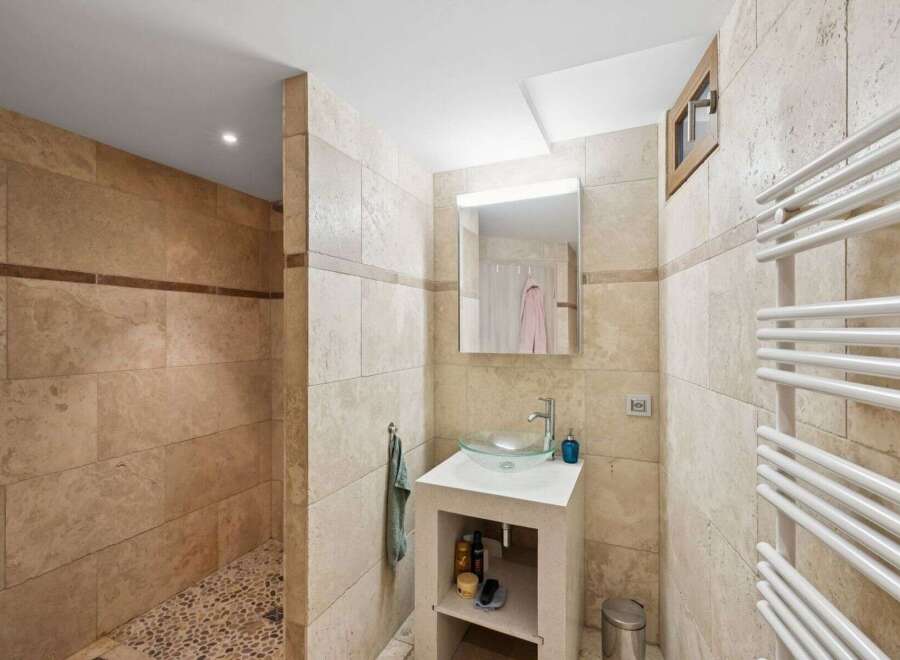 This stunning bathroom boasts a modern design with elegant stone tiles throughout.