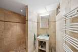 This stunning bathroom boasts a modern design with elegant stone tiles throughout.