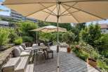 Enjoy outdoor living at its finest with this stunning property featuring a spacious wooden deck and lush greenery.