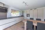 This modern kitchen boasts sleek cabinetry and a spacious layout, perfect for culinary enthusiasts.