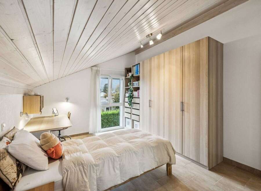 Discover the charm of this inviting bedroom, featuring a cozy bed and ample storage.