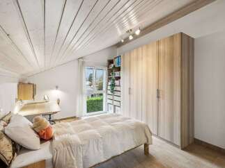 Discover the charm of this inviting bedroom, featuring a cozy bed and ample storage.