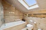 This stunning bathroom features a modern design with a skylight, creating a bright and airy atmosphere.