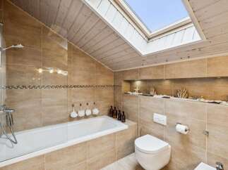 This stunning bathroom features a modern design with a skylight, creating a bright and airy atmosphere.