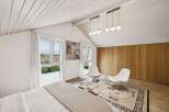 This stunning bedroom boasts a bright and airy atmosphere with its high, white-paneled ceilings and large windows that flood the space with natural light.