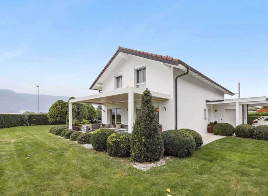 Discover the charm of this stunning modern home, boasting a pristine white exterior and a beautifully landscaped yard.