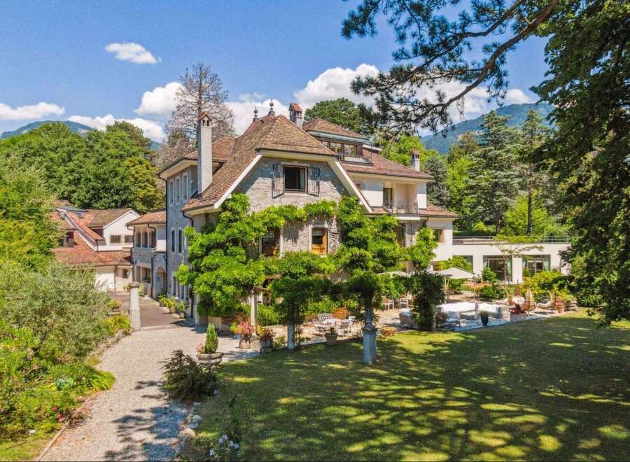 Discover the charm of this stunning property, showcasing a beautiful stone facade and a lush, green landscape.