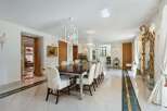 Step into luxury with this exquisite dining room, featuring a grand wooden table and elegant white chairs.