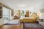 Step into luxury with this exquisite bedroom, boasting a grand, ornate bed and elegant furnishings.