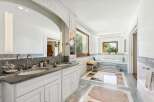 Indulge in luxury within this stunning bathroom, featuring a double vanity with elegant fixtures and ample storage.