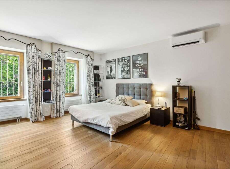 This inviting bedroom boasts a modern design with hardwood floors and ample natural light.