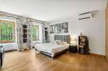 This inviting bedroom boasts a modern design with hardwood floors and ample natural light.
