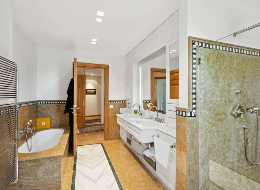Step into luxury with this stunning bathroom featuring a spacious walk-in shower and a relaxing bathtub.