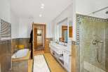 Step into luxury with this stunning bathroom featuring a spacious walk-in shower and a relaxing bathtub.