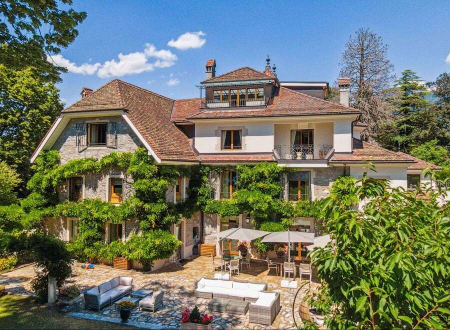 Discover the charm of this stunning property, featuring a beautifully designed exterior with lush greenery and a classic architectural style.