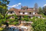 Discover the charm of this stunning property, featuring a beautifully designed exterior with lush greenery and a classic architectural style.