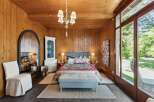 Step into this inviting bedroom, featuring warm wood paneling and a cozy ambiance.