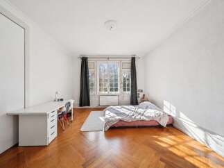 Discover this charming bedroom featuring a spacious white desk with ample storage, perfect for a home office setup.