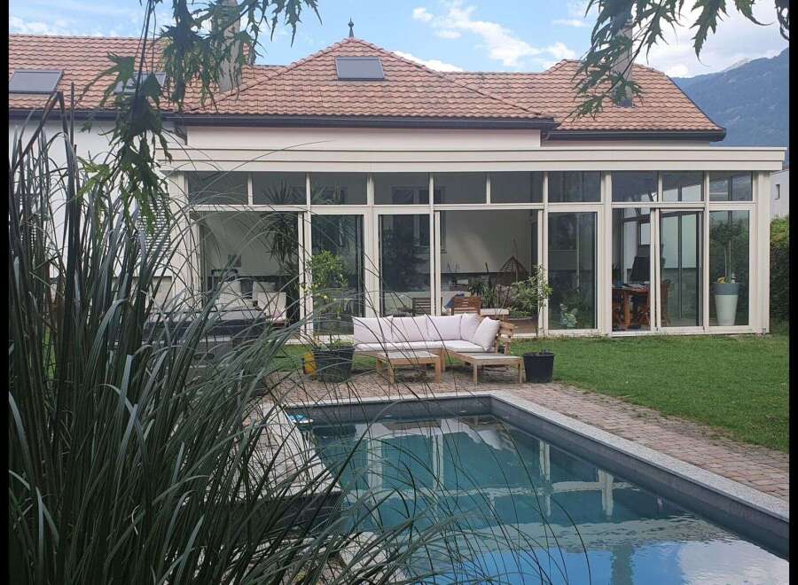 Discover luxury living in this stunning property featuring a beautiful pool and a modern sunroom.