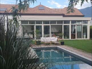 Discover luxury living in this stunning property featuring a beautiful pool and a modern sunroom.