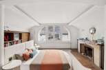 This stunning bedroom boasts a unique architectural design with an arched window offering breathtaking views.