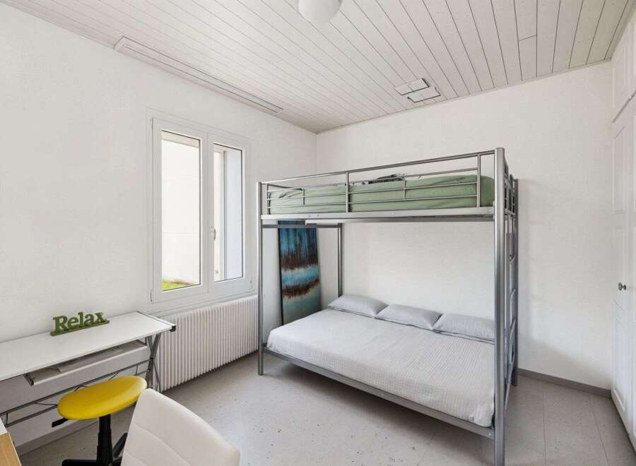 This cozy bedroom features a modern bunk bed, perfect for maximizing space.