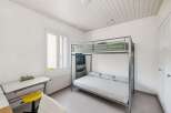This cozy bedroom features a modern bunk bed, perfect for maximizing space.