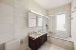 This modern bathroom features a sleek design with a double sink vanity and a bathtub.