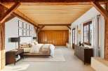 This stunning bedroom showcases rustic charm with exposed wooden beams and a warm, inviting ambiance.
