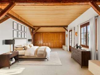 This stunning bedroom showcases rustic charm with exposed wooden beams and a warm, inviting ambiance.