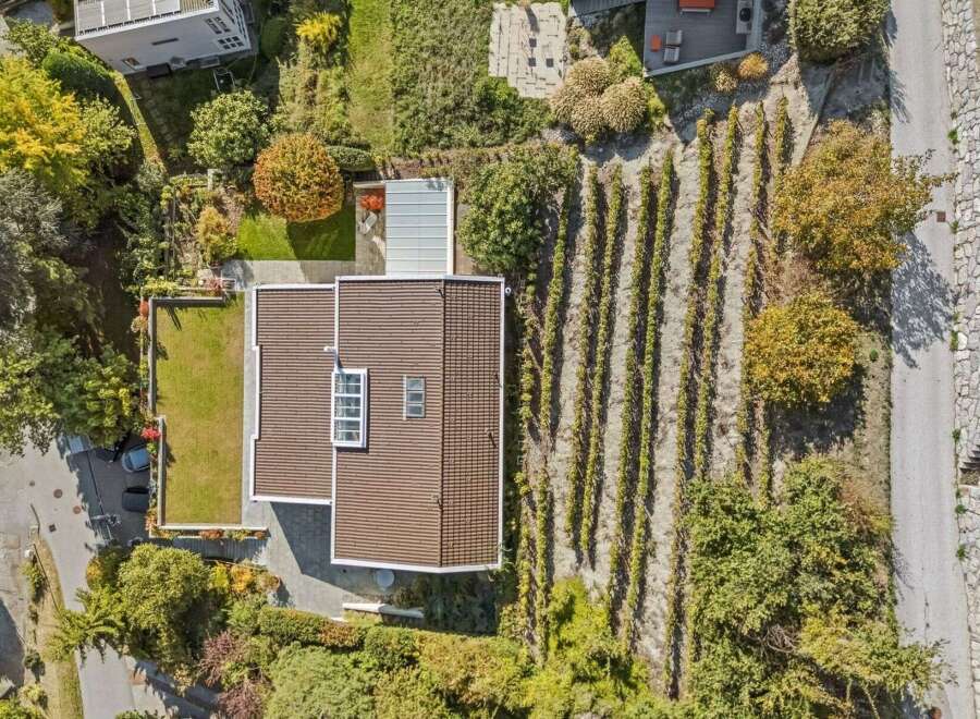 Discover this stunning property featuring a modern house with a beautifully designed roof and a lush green lawn.