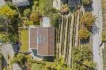 Discover this stunning property featuring a modern house with a beautifully designed roof and a lush green lawn.