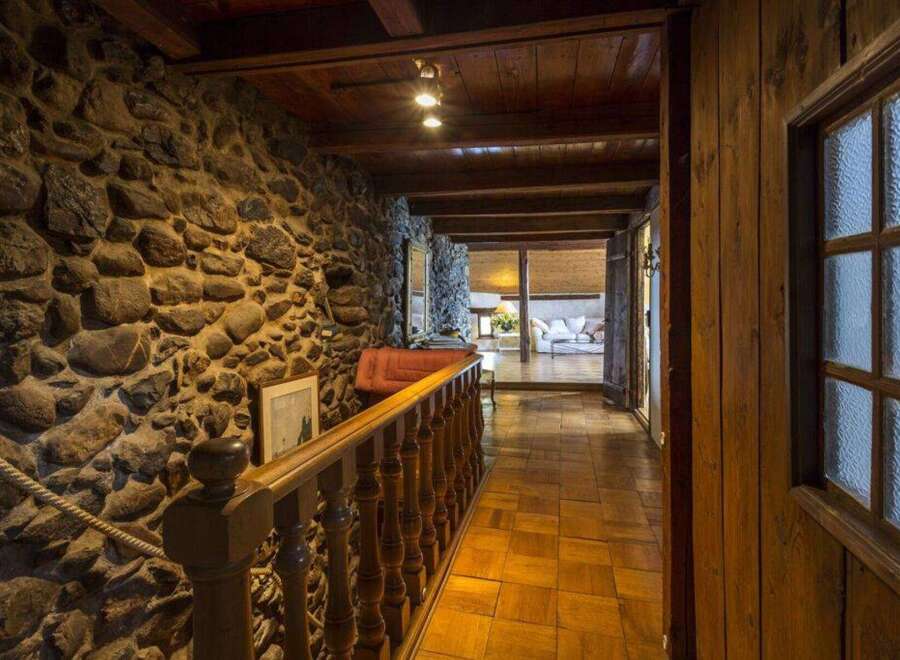 Step into rustic elegance with this stunning property featuring a stone wall hallway.