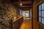 Step into rustic elegance with this stunning property featuring a stone wall hallway.