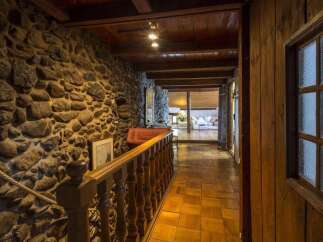 Step into rustic elegance with this stunning property featuring a stone wall hallway.
