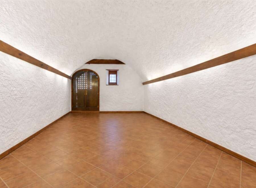 Step into this unique space featuring a rustic, arched ceiling and textured walls, creating a charming ambiance.