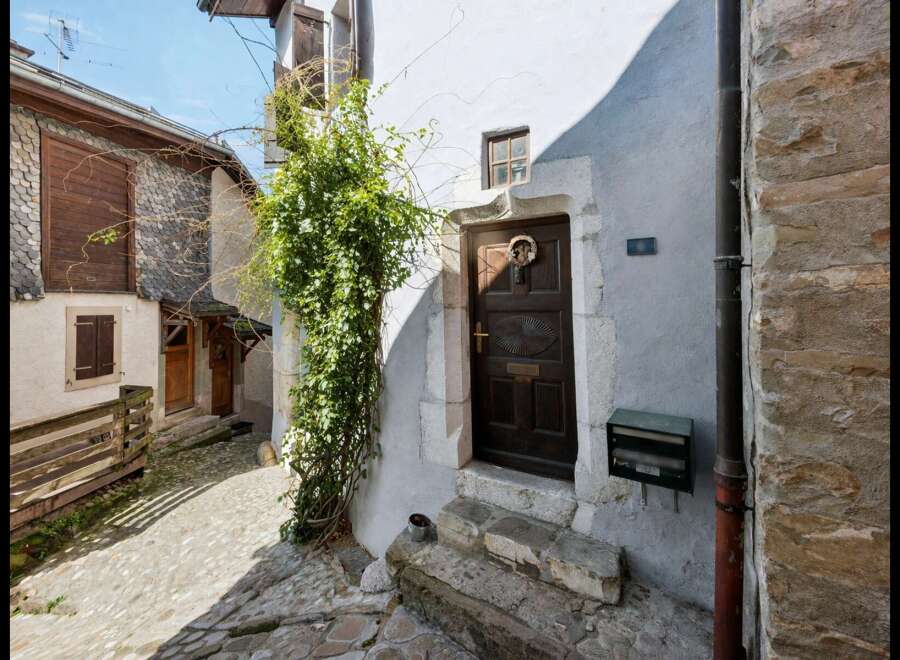 Discover the charm of this historic property, featuring a beautifully crafted wooden door and stone steps.