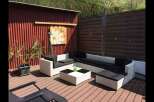 Enjoy outdoor living at its finest with this stunning property! This space features a modern white wicker sofa set with black cushions, perfect for relaxing and entertaining.