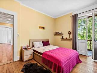 This charming bedroom offers a cozy retreat with its warm color palette and inviting ambiance.
