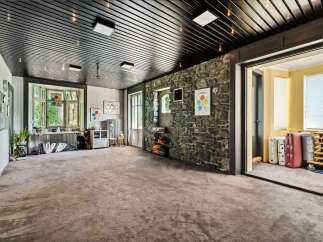 This spacious room boasts a unique blend of rustic and modern design elements, perfect for a variety of uses.