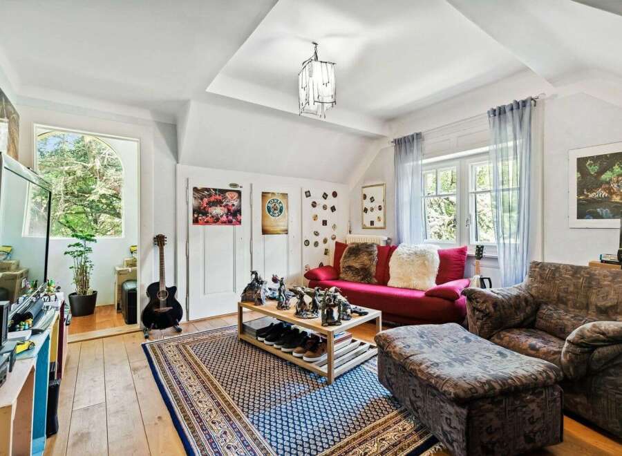 This cozy living space features a vibrant red sofa, perfect for relaxing.
