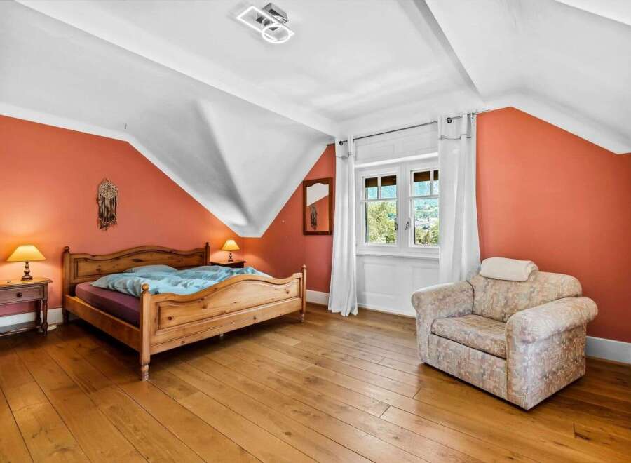 This charming bedroom features a cozy wooden bed frame and warm, inviting hardwood floors.