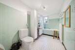 Step into this charming bathroom, featuring a classic design with mint green tiles and a bright, airy feel.