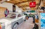 Step into a classic car enthusiast's dream garage! This space features a vintage Rover sign, a beautifully restored classic car, and a well-organized workshop area.