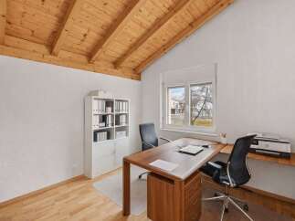 This stunning home office features a beautiful wooden ceiling and a large window that provides ample natural light.
