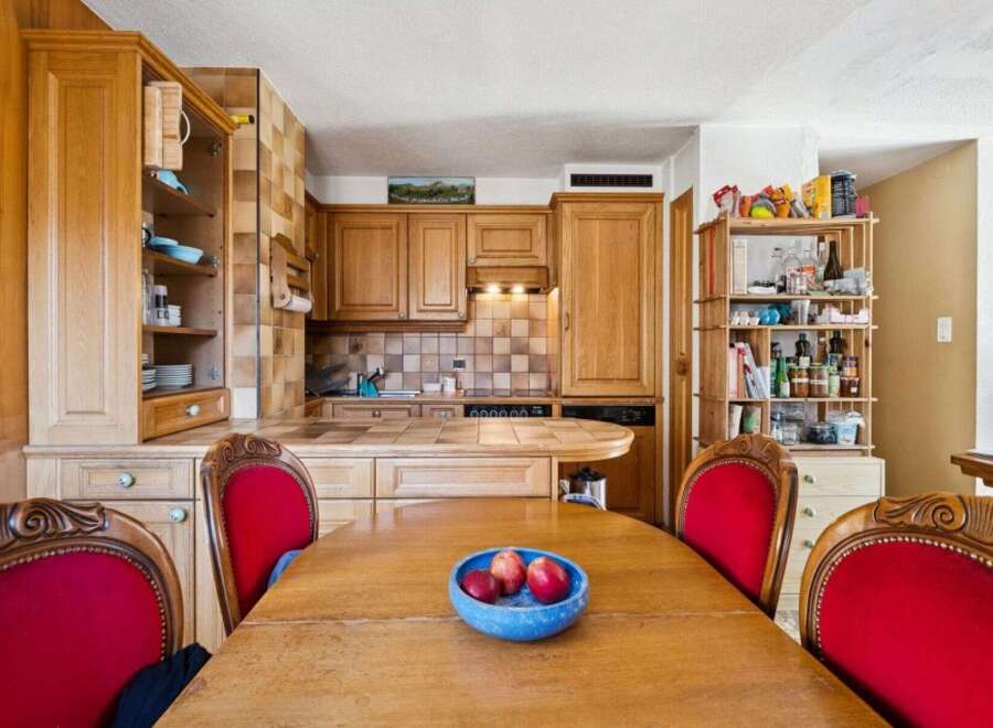 This charming kitchen boasts beautiful wooden cabinetry and a cozy dining area.